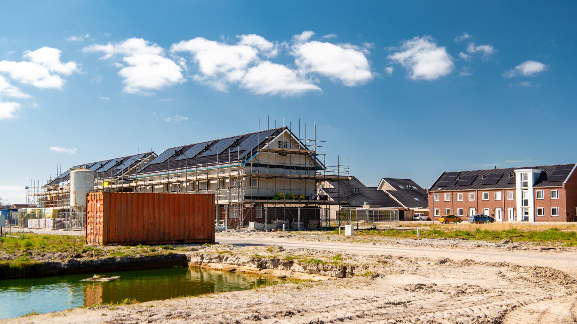Newly build houses with solar panels attached on the roof against a sunny sky